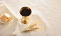 Chalice and host with wheat spikes on white tablecloth