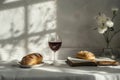 A chalice of wine and a loaf of bread are shown against a light background. This represents the Holy Communion. Royalty Free Stock Photo