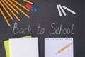 The chalk on the blackboard, back to school, a set of pencils and an eraser, there is a place for writing on a white notepad Royalty Free Stock Photo