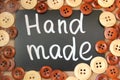 Chalk Board with the inscription `handmade` surrounded by brown and white wooden buttons Royalty Free Stock Photo