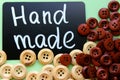 Chalk Board with the inscription `handmade` surrounded by brown and white wooden buttons Royalty Free Stock Photo