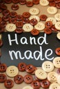 Chalk Board with the inscription `handmade` surrounded by brown and white wooden buttons Royalty Free Stock Photo