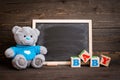 Chalk board and teddy bear on a wooden background Royalty Free Stock Photo