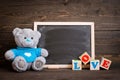 Chalk board and teddy bear on a wooden background Royalty Free Stock Photo
