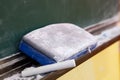 Chalk and brush resting on black board Royalty Free Stock Photo