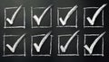 Chalk checkmarks on blackboard create checklist image. Hand drawn boxes with ticks. Simple checklist design for tasks votes. Royalty Free Stock Photo