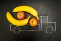 Chalk painted truck loaded with bananas and apples on a black background