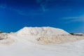 Chalk quarry. White sand hill, roads, blue sky. Limestone mining or desert
