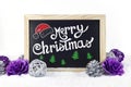 Chalkboard with Christmas decoration on snow white isolated background, and text `Merry Christmas` written on it Royalty Free Stock Photo