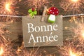 Chalkboard with four leaf clover and chimney sweeper and sparklers with bonne annee 2020 on wooden background