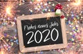 Chalkboard with four leaf clover and chimney sweeper and sparklers with happy new year 2020