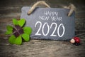 Chalkboard with four leaf clover and chimney sweeper and sparklers with happy new year 2020