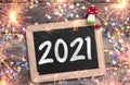 Chalkboard with four leaf clover and chimney sweeper and sparklers with happy new year 2021 on wooden background