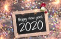 Chalkboard with four leaf clover and chimney sweeper and sparklers with happy new year 2020