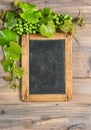 Chalkboard grapes green vine leave wooden background Royalty Free Stock Photo