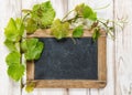 Chalkboard green vine leaves farmhouse wooden background Royalty Free Stock Photo