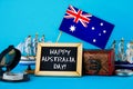 Chalkboard with the inscription: Happy day of Australia surrounded by shipwrights, a compass, a clock and an Australian flag on a