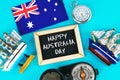 Chalkboard with the inscription: Happy day of Australia surrounded by shipwrights, a compass, a clock and an Australian flag on a