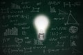 Chalkboard with math formula and idea concept bright glowing light bulb Royalty Free Stock Photo