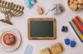 Chalkboard with menorah and sufganiyot over white background. Retro filter effect. View from above Royalty Free Stock Photo