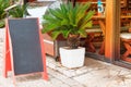 Chalkboard menu black color for text, message or advertising. Mockup is standing near the restaurant on seashore. Royalty Free Stock Photo