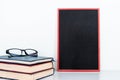 Chalkboard mock up frame and old books with eyeglasses Royalty Free Stock Photo