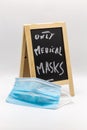 Chalkboard with note only medicals masks as warning with medical mask in the foreground at Covid-19 times