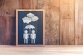 Chalkboard with people shape paper cut in raining and umbrella Royalty Free Stock Photo