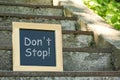 Chalkboard with phrase Don`t Stop on stone stairs outdoors, space for text Royalty Free Stock Photo