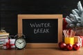 Chalkboard with phrase Winter Break, Christmas decor and stationery on wooden table. Holidays concept Royalty Free Stock Photo