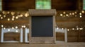 Chalkboard Sign on Wooden Table With Blurred String Lights in Background at Evening Gathering Royalty Free Stock Photo
