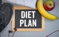 Chalkboard with sport shoes, fruits, towel and diet plan