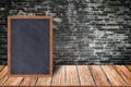 Chalkboard wood frame, blackboard sign menu on wooden table and brick wall background. Royalty Free Stock Photo