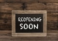 Chalkboard wooden background Reopening soon Royalty Free Stock Photo