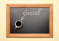 Chalkboard with word decaf and cup of coffee on beige background, top view Royalty Free Stock Photo