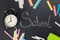 On the chalkboard written word school around lies a multi-colored chalk and the clock lies Royalty Free Stock Photo