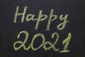 Chalkboard with yellow chalk handwritten inscription Happy 2021.