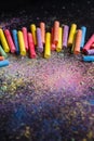 Chalks in a variety of colors on black background..