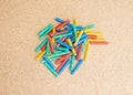 Chalks in a variety of colors on a corkboard