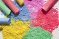 Chalks in a variety of colors on white background, chalk powder.