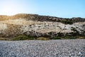 Chalky limestone mountains and pebbles on Shingle beach in Cyprus