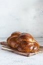 Challah or Hala is a traditional jewish sweet fresh sabbath Braided bread loaf, fresh bun on cutting board.