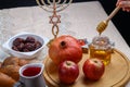 challah, wine, apple dates and honey on a wooden round board for Rosh hashanah celebration.
