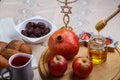 challah, wine, apple dates and honey on a wooden round board for Rosh hashanah celebration.