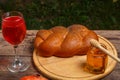 Challah wine in a glass and honey on a wooden table on planks for rosh hashanah