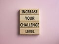 Challenge Level symbol. Concept word Increase your Challenge Level on wooden blocks. Beautiful pink background. Business and