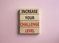 Challenge Level symbol. Concept word Increase your Challenge Level on wooden blocks. Beautiful pink background. Business and