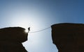 Challenge, risk, concentration and bravery concept. Silhouette a man balance walking on rope over precipice Royalty Free Stock Photo