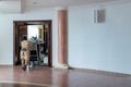 Chambermaid pushing cart along corridor in hotel. Maid at work and trolley with room supplies and cleaning equipment in