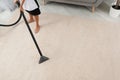 Chambermaid removing dirt from carpet with vacuum cleaner indoors, closeup. Royalty Free Stock Photo